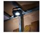 Une lampe de travail Parkside suspendue à un cadre métallique dans une pièce avec des panneaux de bois.