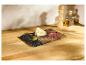 Planche de fromages avec fromage, jambon et câpres sur un comptoir en bois.