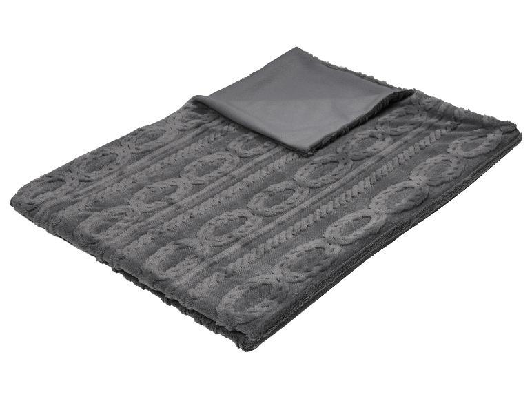 Couverture grise douce avec motif tressé, pliée, avec un côté lisse visible