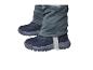 Gros plan des jambes d'un enfant portant un pantalon d'hiver gris et des bottes d'hiver bleu foncé.