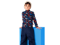Enfant en col roulé imprimé montagne et pantalon de ski bleu foncé.