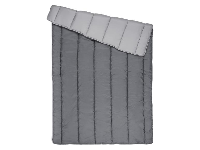 Sac de couchage bicolore dans les tons de gris, déplié.