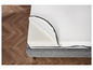 Un matelas blanc avec une housse grise sur un sol en bois.