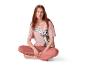 Femme assise en pyjama rose Tom et Jerry sur fond blanc.