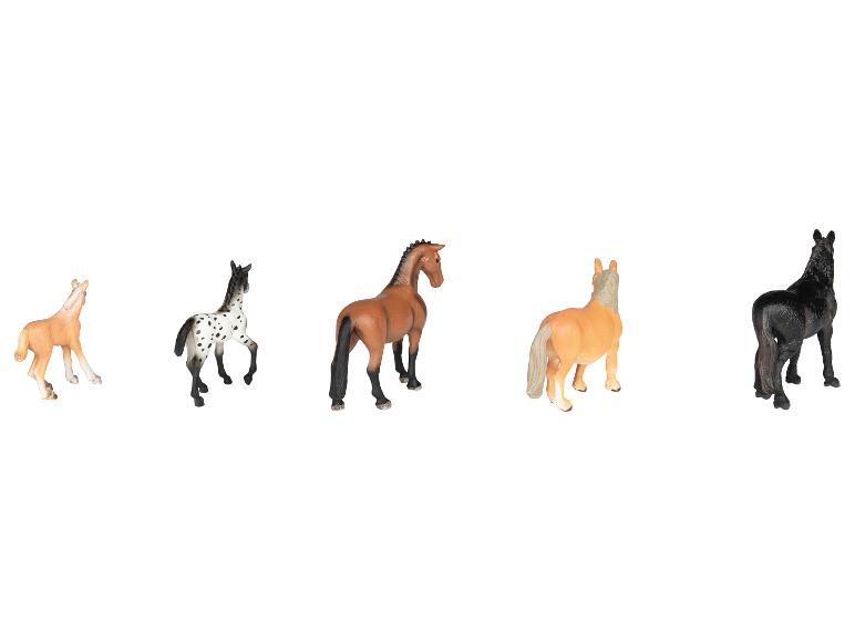 Cinq figurines de chevaux jouets de différentes couleurs et races, sur fond blanc