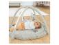 Bébé allongé sur un tapis d'éveil FEHN avec des jouets suspendus.