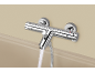 Mitigeur thermostatique chromé pour douche de baignoire avec eau coulant dans la baignoire.