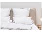 Oreillers et couette blancs avec bordure marron sur un lit, avec étiquette 'fjödur'.
