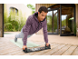 Homme faisant des pompes sur une planche à pompes en extérieur.