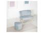 Fauteuil et pouf cœur en velours bleu avec pieds en bois sur un sol blanc.