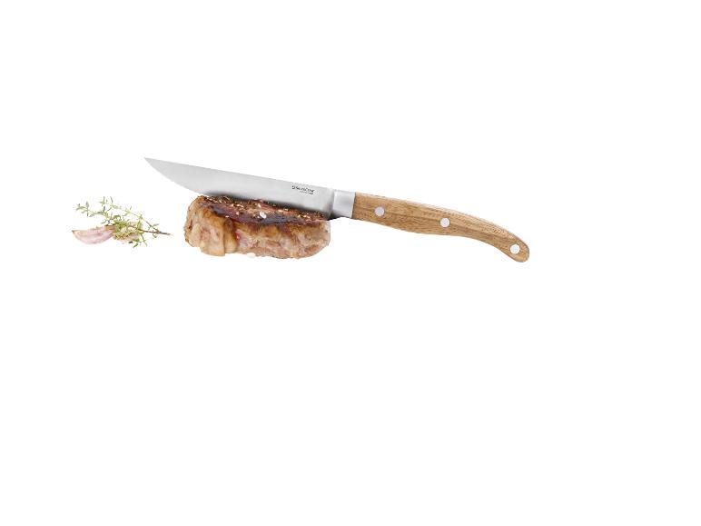 Steak avec couteau, ail et thym sur fond blanc.
