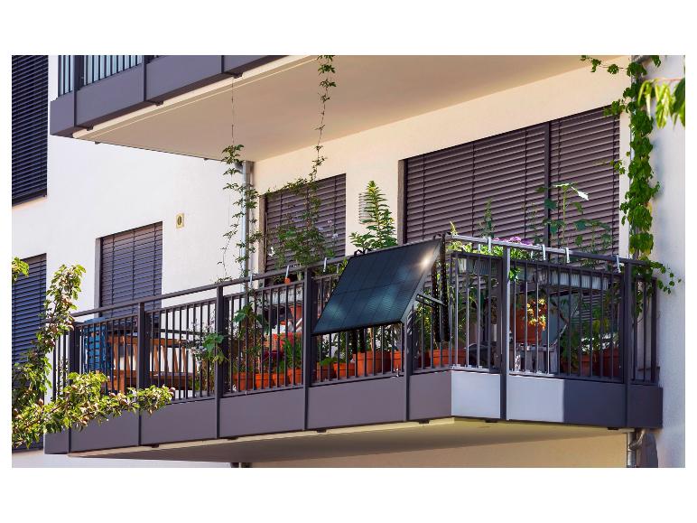 Un balcon avec un panneau solaire, des plantes et une balustrade en métal.