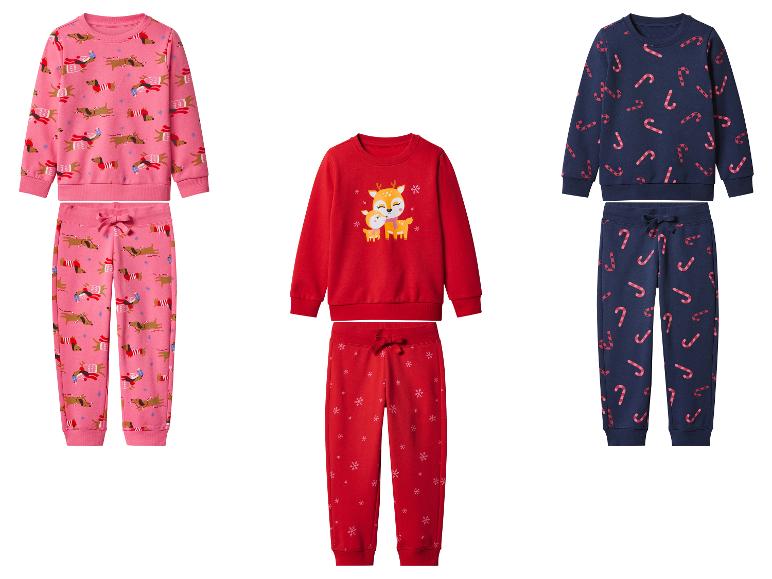 Trois ensembles de pyjamas de Noël pour enfants : rose avec des teckels, rouge avec des rennes et bleu marine avec des cannes à sucre.