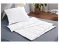 Une couette et un oreiller blancs sur un lit gris