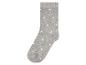 Une chaussette grise à pois blancs.