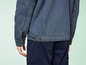 Une veste en jean bleue avec des boutons et un pantalon cargo bleu foncé.