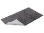 Tapis de bain gris moelleux avec base antidérapante, vu en angle.