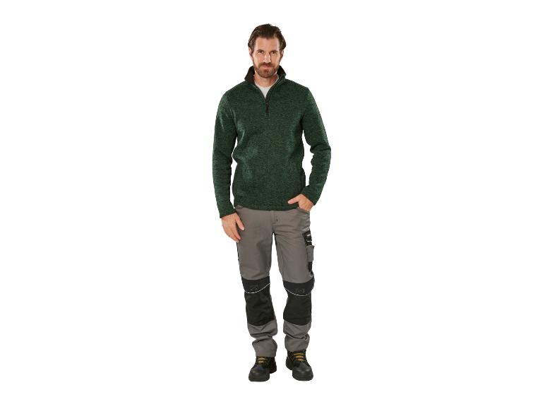 Homme en pull vert et pantalon de travail gris