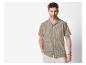 Homme en chemise à manches courtes rayée beige et pantalon clair.