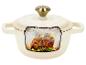 Cocotte crème avec couvercle, remplie d'un carré d'agneau rôti et de légumes.