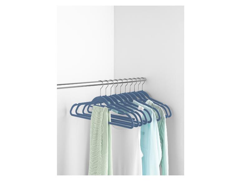 Cintres en velours bleu avec des vêtements dans un placard.