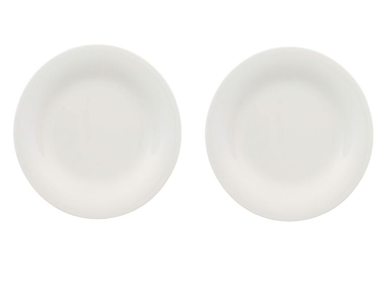 Deux assiettes en céramique blanches, placées côte à côte sur un fond blanc.