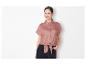 Chemisier noué rose et jeans noirs pour femme.