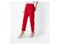 Femme en pantalon rouge et talons hauts gris sur fond blanc.