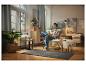 Femme se relaxant dans un fauteuil à la maison, entourée de meubles et de décorations de style scandinave.