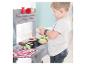 Enfant jouant avec un barbecue jouet en bois et de la nourriture en peluche.