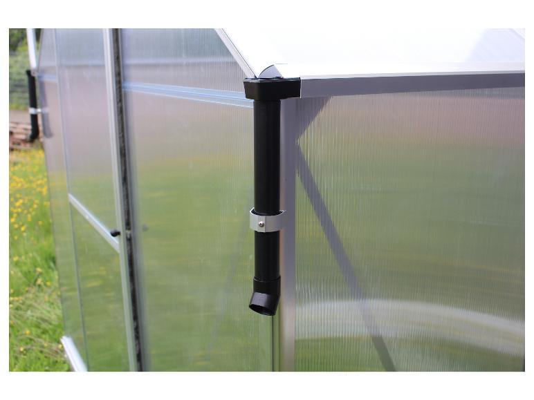 Gros plan sur une serre transparente avec un tuyau d'évacuation noir.