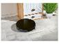 Un aspirateur robot noir sur un sol en carrelage gris