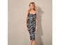 Une femme porte une robe midi zébrée noire et blanche.