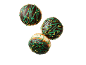 Trois beignets avec glaçage au chocolat, décoration verte et pistaches.