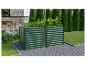 Jardinière surélevée verte avec légumes, à côté d'une terrasse extérieure et pelouse.
