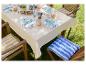Table d'extérieur avec vaisselle, coussin rayés bleu et jaune.