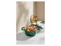 Une cocotte en fonte verte remplie de viande rôtie et de légumes, avec une bouteille d'huile à proximité.