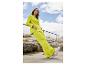 Femme en costume jaune vif et baskets blanches.