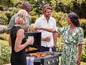 Un groupe d'amis profite d'un barbecue avec des légumes et de la viande grillés.