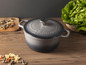 Une cocotte en fonte grise MasterPro avec couvercle sur une table en bois