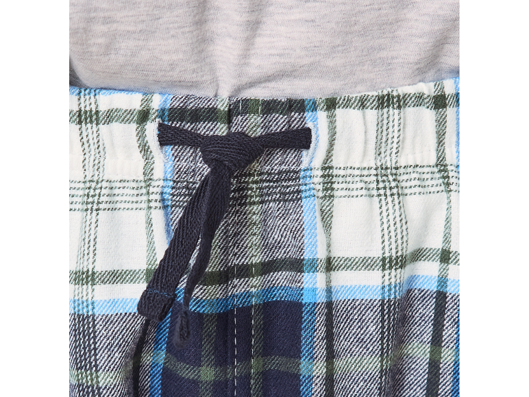 Pantalon de pyjama à carreaux avec cordon de serrage à la taille et un t-shirt gris.