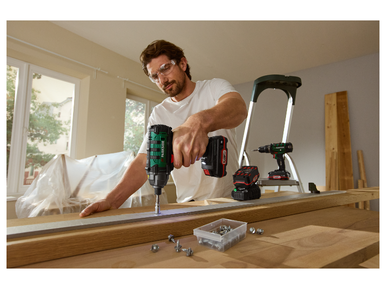 Un homme utilise une visseuse sans fil Parkside pour travailler le bois.
