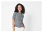 Une femme porte un t-shirt gris à manches courtes en tricot.