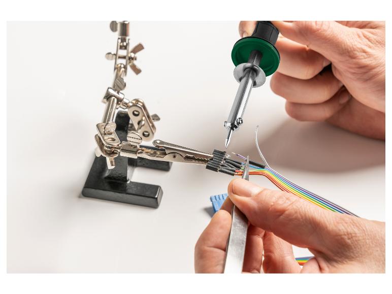 Un fer à souder est utilisé pour souder des fils avec un câble arc-en-ciel.