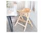 Chaise haute en bois pour bébé avec table blanche et vaisselle pastel.