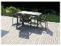 Une table de jardin en bois avec quatre chaises à dossier tressé sur une terrasse en bois.