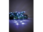 Branche de sapin de Noël avec des guirlandes LED blanches sur fond sombre.