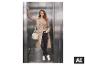 Femme en trench-coat beige, jean noir et baskets blanches dans un ascenseur.