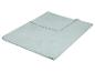 Couverture polaire bleu clair pliée sur fond blanc