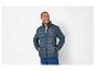 Un homme portant une veste matelassée bleu foncé.